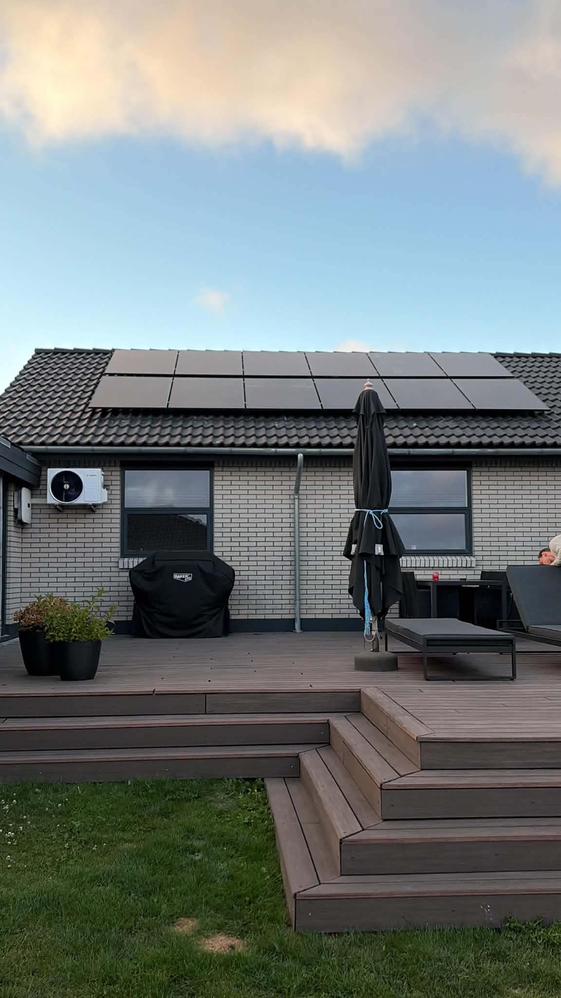 Parcelhus med solceller på taget og inverter på væggen